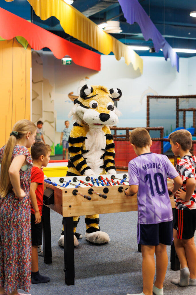Maskota tigrić Tobi igra stolni nogomet s djecom tijekom dječjeg rođendana u Kids Jungle igraonici